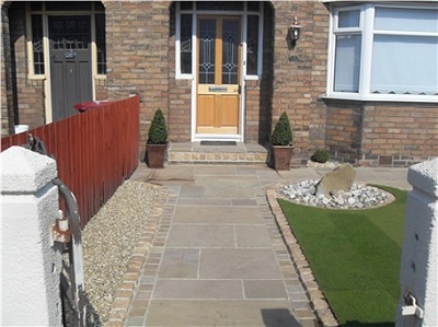 A finished hard-landscaping garden with paving, lawn edge and timber fencing.